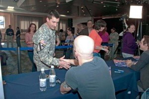 Photo by Greg JonesStaff Sgt. Paul Smith shakes hands with Chris Daughtry, lead singer of the band Daughtry, during an autograph signing after the special concert in the Patch Community Club March 17.
