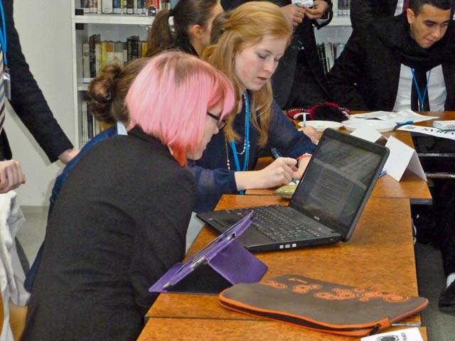Loren PreussPatch High School student Zoya Pennwell (left) and an international student research a resolution at the Prague Model UN Conference in January.