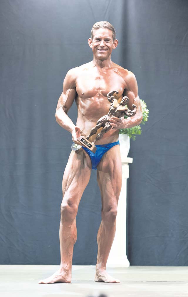 George Bond, representing Stuttgart, proudly displays his trophy for winning the Men’s Bodybuilding Master Class.Photos by Laura Castro.