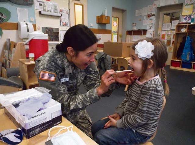 Photo by Rachel BradshawMaj. Leslie Oakes, the pediatric dentist at the Stuttgart Dental Clinic, encourages Annika Lindstrom, 5, to “open wide” during a dental screening at the Kelley Child Development Center Feb. 11. February is National Children’s Dental Health Month. During the month, Oakes and other providers from the dental clinic conducted dental screenings at the local elementary schools and child development centers, and talked to children about good oral habits.