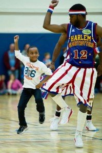 Tyler Jackson, 7, dances with “Ant” Atkinson after helping the Globetrotter with a trick shot.