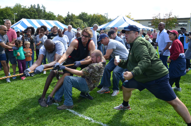 Ever a coach and champion for his employees, Gregory Holzinger, the director of U.S. Army Garrison Stuttgart’s Family and Morale, Welfare and Recreation (right), encourages the Family and MWR team during last year’s garrison organization day. Photo by S.J. Grady.