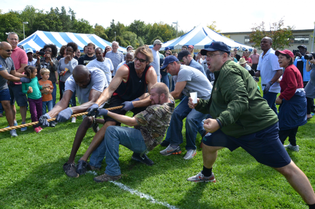 Ever a coach and champion for his employees, Gregory Holzinger, the director of U.S. Army Garrison Stuttgart’s Family and Morale, Welfare and Recreation (right), encourages the Family and MWR team during last year’s garrison organization day.  Photo by S.J. Grady. 