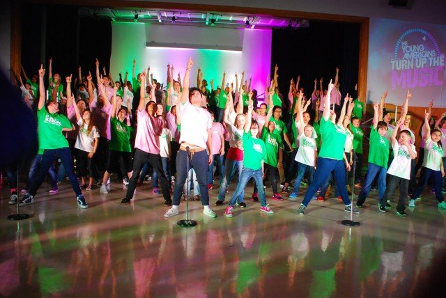 Nearly 100 Camp Zama youth members perform alongside The Young Americans during a community concert earlier this year. The Young Americans comes to Stuttgart April 30 to May 2. — U.S. Army photos by Terrence Holden. 