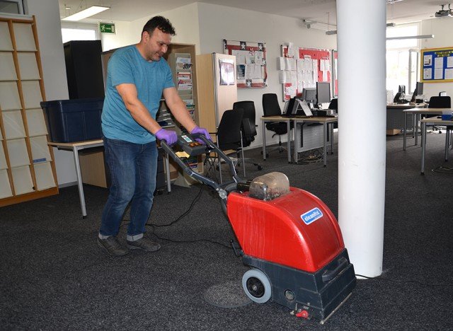 A contractor works on cleaning the carpet in Army Community Service April 16. Photo by S.J. Grady.