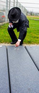 Rabbi Netanel Wurmser, State Rabbi of the Israelite Religious Community Württemberg, places white stones on gravestones during a memorial ceremony at the Jewish gravesite on Stuttgart Army Airfield April 16.