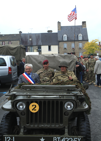 Lt.  Col. Jack Kredo, SOCEUR commandant, Andre Denot, the mayor of Ponterson, France, and Michel Paysant in a U.S. World War II uniform, lead a parade with local grade-school students through town. This was the first time since the liberation in 1945 that American troops have been in Pontorson for an official event. Photo by Sgt. 1st Class Will Patterson, SOCEUR Public Affairs.