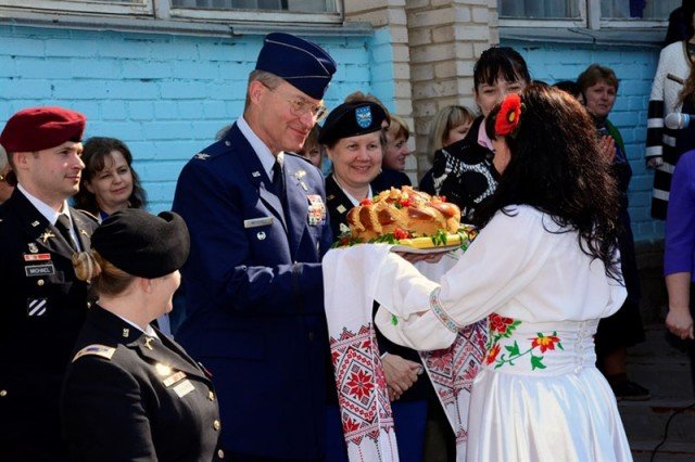 Col. John Mitchell, U.S. European Command surgeon general, receives a ceremonial gift of bread during the start of a ceremony at School #16 April 27, 2015. The school received office furniture, such as desks, tables and chairs donated by U.S. Department of Defense, European Command (EUCOM) in cooperation with the Office of Defense Cooperation (ODC), United States Agency for International Development (USAID), and Ukraine. The property transfer coordination began in 2012 at EUCOM to provide infrastructure improvement for the school, which is attended by nearly 1,200 students. (U.S. European Command photo by Master Sgt. Charles D. Larkin Sr./RELEASED)