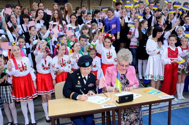 Col. Cynthia Matuskevich, Office of Defense Cooperation chief, signs a property transfer letter during a ceremony at School #16 April 27, 2015. The school received office furniture, such as desks, tables and chairs, donated by U.S. Department of Defense, European Command (EUCOM) in cooperation with the Office of Defense Cooperation (ODC), United States Agency for International Development (USAID), and Ukraine. The property transfer coordination began in 2012 at EUCOM to provide infrastructure improvement for the school, which is attended by nearly 1,200 students. (U.S. European Command photo by Master Sgt. Charles D. Larkin Sr./RELEASED)