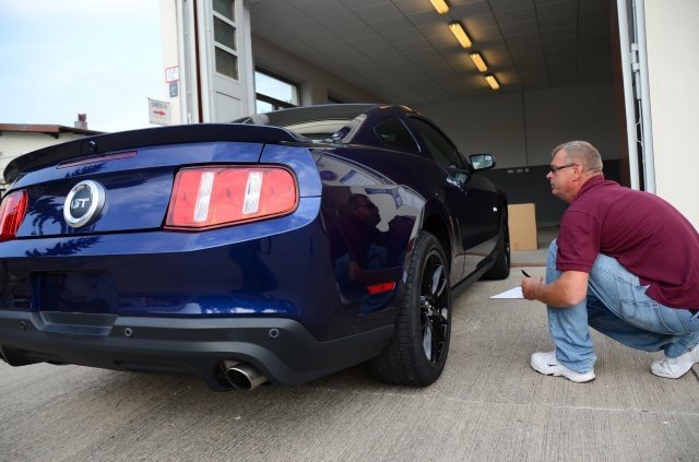 Roger Fox, manager of the USAG Ansbach Vehicle Processing Center at Barton Barracks, checks an outbound vehicle for damage before shipment. (U.S. Army photo by Stephen Baack, USAG Ansbach Public Affairs)