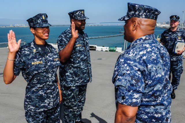 Master Chief Personnel Specialist Jay McNuckle and his wife Senior Chief Master-at-Arms Latisha McNuckle re-enlist together on the flight deck aboard the amphibious assault ship USS Boxer (LHD 4). The McNuckle's have been married 17 years. Boxer is preparing for an upcoming deployment later this year. (U.S. Navy photo by Mass Communication Specialist 3rd Class Brian Jeffries/Released)