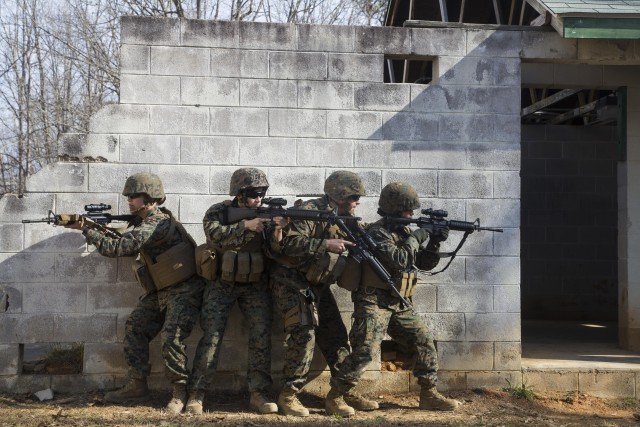 Female Marines and a male sailor, all assigned to the 22nd Marine Expeditionary Unit, prepare to enter a building during an urban operations training exercise with a female engagement team at Fort Pickett, Va., Feb. 21, 2016. Defense Secretary Ash Carter announced today that the services are authorized to begin integrating women into all military occupations and specialties. Marine Corps photo by Lance Cpl. Koby I. Saunders
