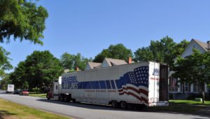 An 18-wheeler unloads household goods; with PCS season upon us, many more trucks will soon be delivering hundreds of tons of personal belongings.