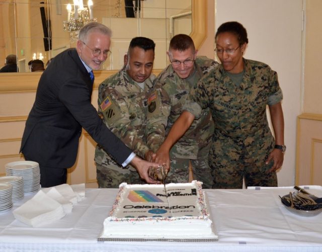 Joseph L. Cox, U.S. Africa Command, Command Sgt. Maj. Mariano Alvarez and Commander, Col. Glenn K. Dickenson of U.S. Army Garrison Stuttgart and Marine Corps Sgt. Deidra Freeman cut the cake closing USAG Stuttgart's first Lesbian, Gay, Bisexual and Transgender Pride Month observance held, June 24, 2016 at the Swabian Special Event Center on Patch Barracks. 