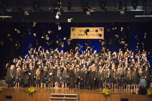 Students perform one last task of firsts by tossing their mortar boards in the air after moving the tassel from right to left, indicating their status as the first graduates from the new Stuttgart High School.