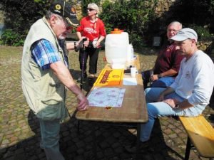 Photo Credit: Donald Seltzer A German volksmarcher checks the trail map at one of the Wiesbaden International Wandering Club event checkpoints while another participant picks up some of the sweet tea and water offered as refreshment. Volunteers Brad Crandall of the Ramstein Roadrunners club and Klaus Michels of the WIWC man the control point on the 12-kilometer trail.