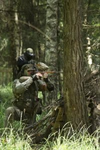 Blue Force team members push forward to the opposing team positions in the local training area woodland paintball field at the Outdoor Recreation paintball event.