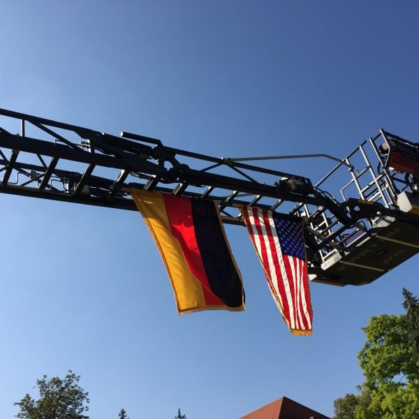 The German and American flags fly from the ladder of a fire truck during the Patriot Day Ceremony held, Sept. 9, 2016 on Panzer Kaserne.