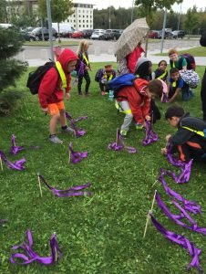 Children and communty members plant purple flags for Domestic Violence Awareness Month, Oct. 3, 2016 in front of the Exchange on Panzer Kaserne. Photo by Holly DeCarlo-White 