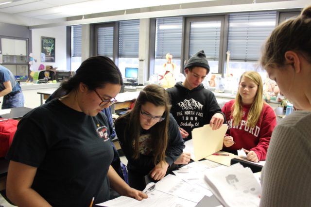 Students sift through evidence to solve a simulated crime.