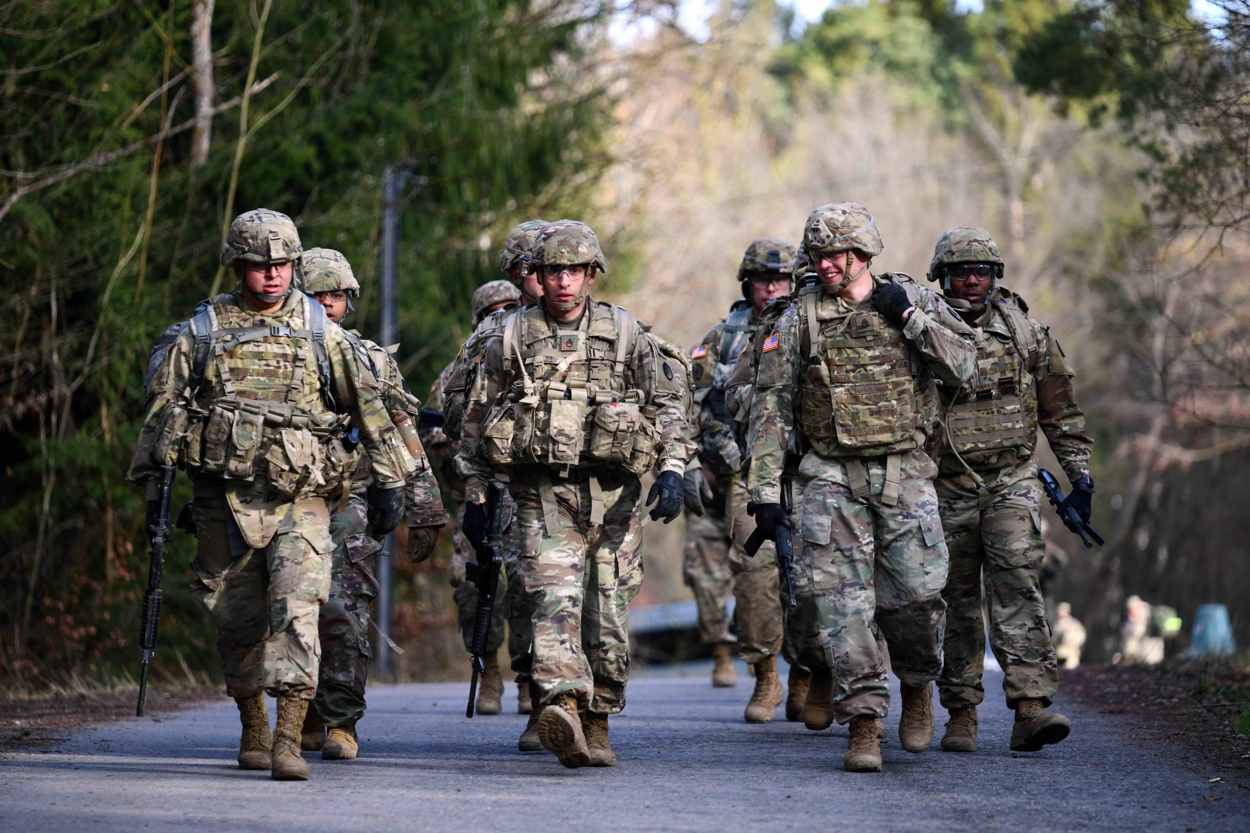 A group of soldiers in camoflage walk towards the camera