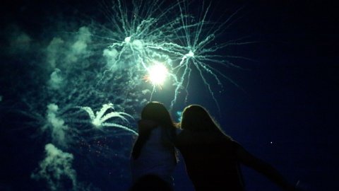 Children silhouetted against fireworks
