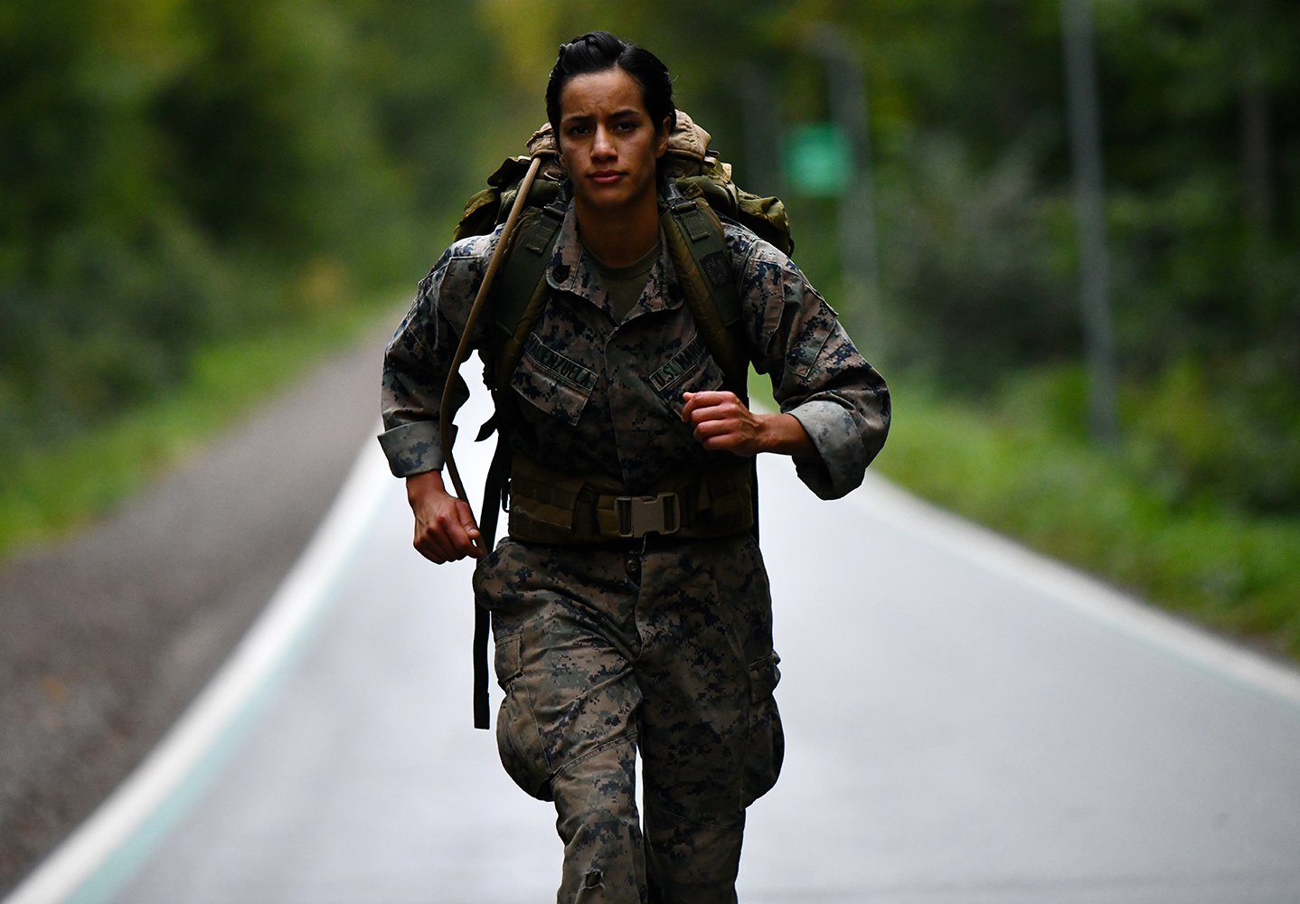 A Female Marine running a ruck march