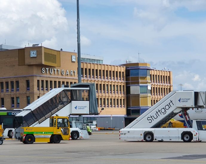 A stock image of a Stuttgart Airport building and support vehicles seen from an apron.