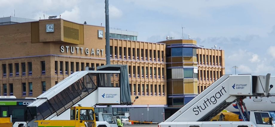 A stock image of a Stuttgart Airport building and support vehicles seen from an apron.